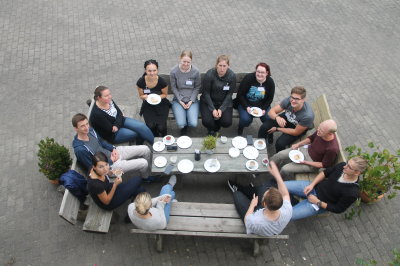 Teilnehmer sitzen am Tisch und machen ihre Kaffeepause während des ersten jährlichen Retreats