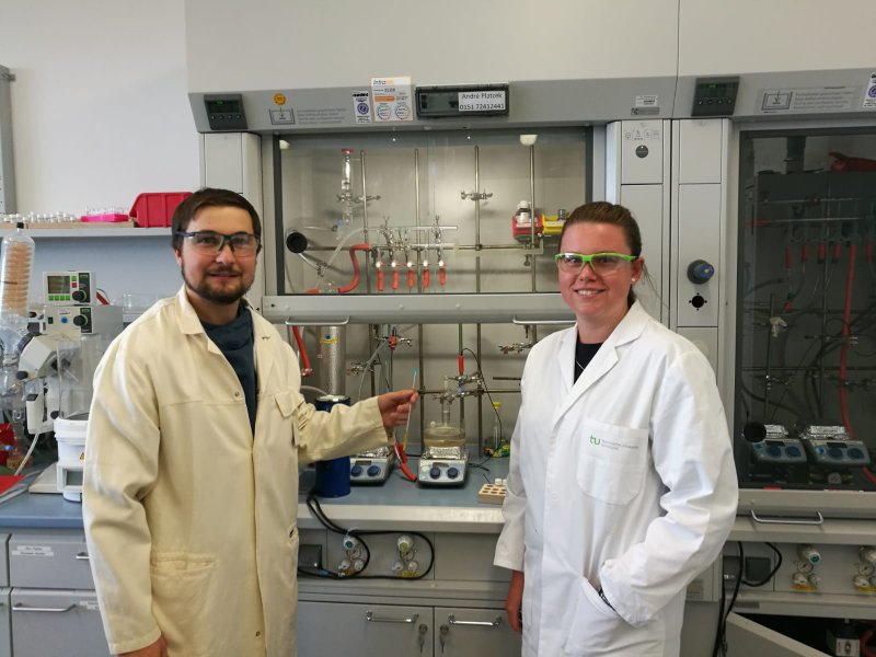 PhD students in the lab during the lab experience PhD students are standing in front of their experiment apparatus in the lab